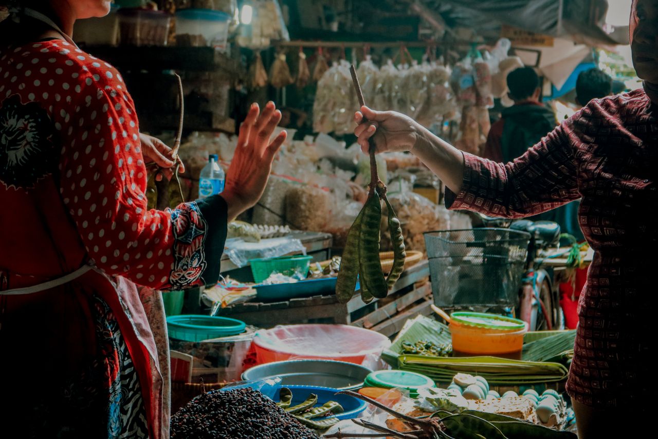 transaksi-jual-beli-pedagang-pasar-tradisional Pedagang dan pembeli melakukan transaksi jual beli bahan pangan di pasar tradisional