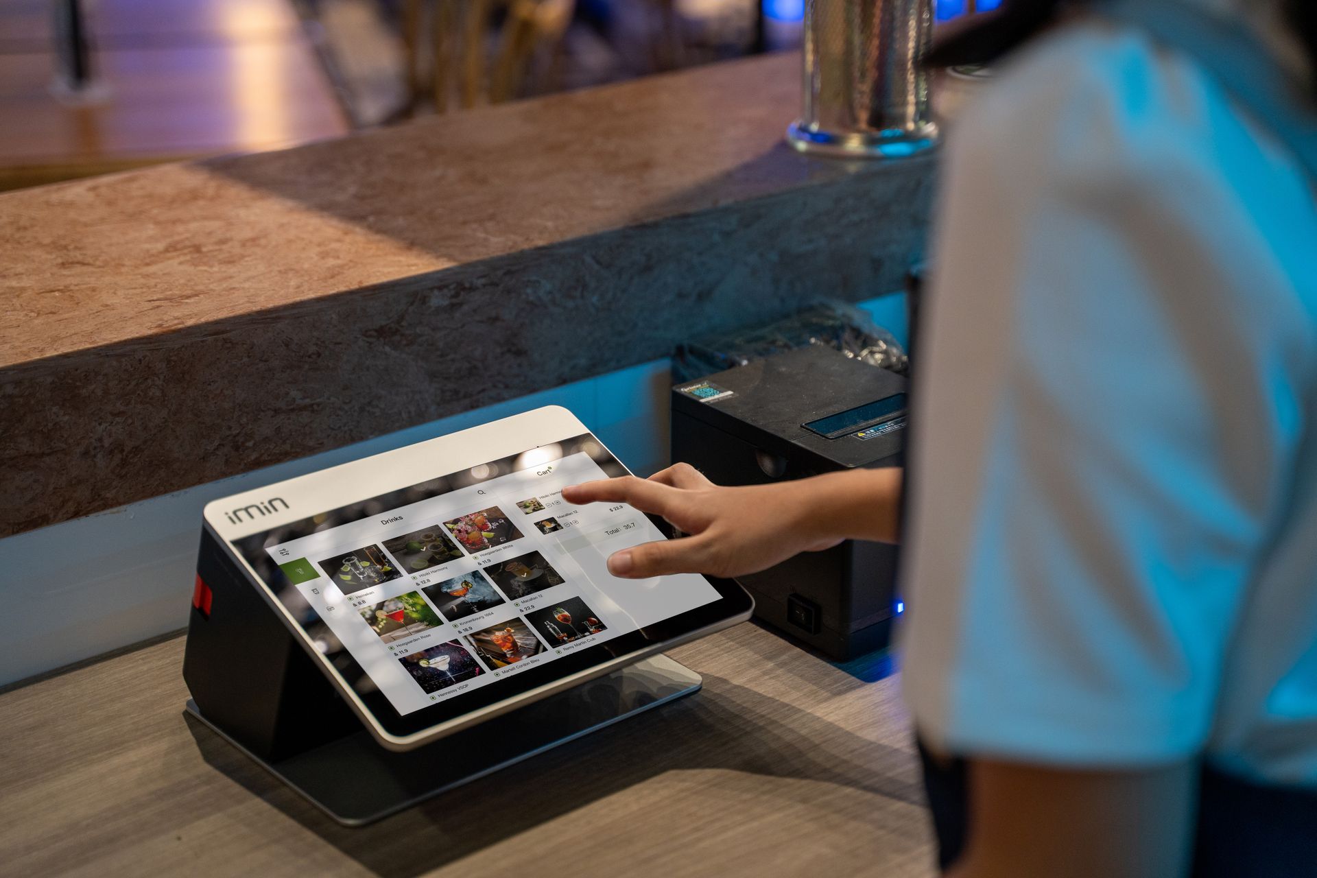 aplikasi-kasir-perangkat-pos-restoran-dan-bar-kasair Kasir mengoperasikan sistem aplikasi kasir restoran pada layar touchscreen pintar menggunakan Kasair POS