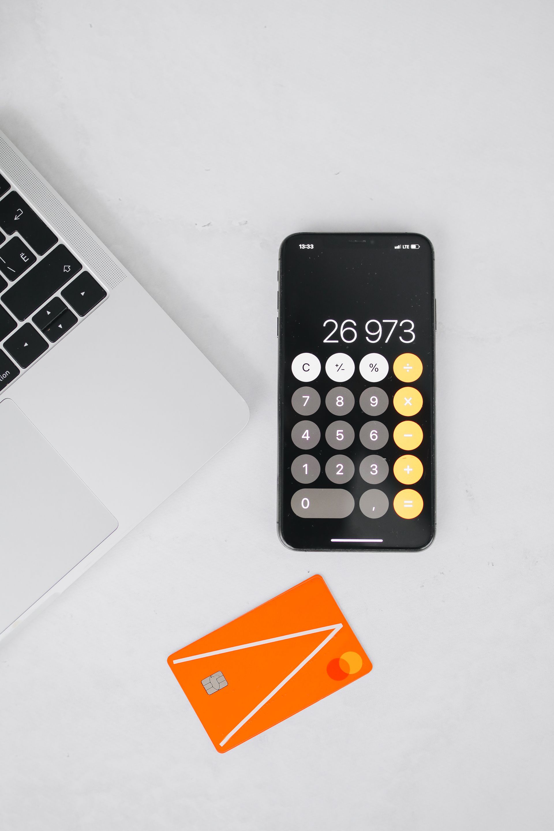 Smartphone dengan aplikasi kalkulator dan kartu pembayaran untuk perencanaan keuangan digital