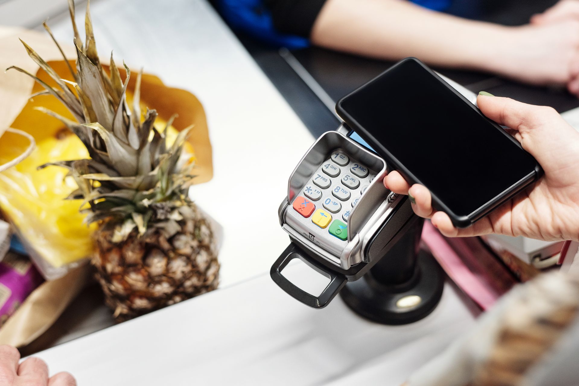pembayaran-nontunai-dengan-smartphone Pelanggan melakukan pembayaran menggunakan smartphone pada mesin EDC