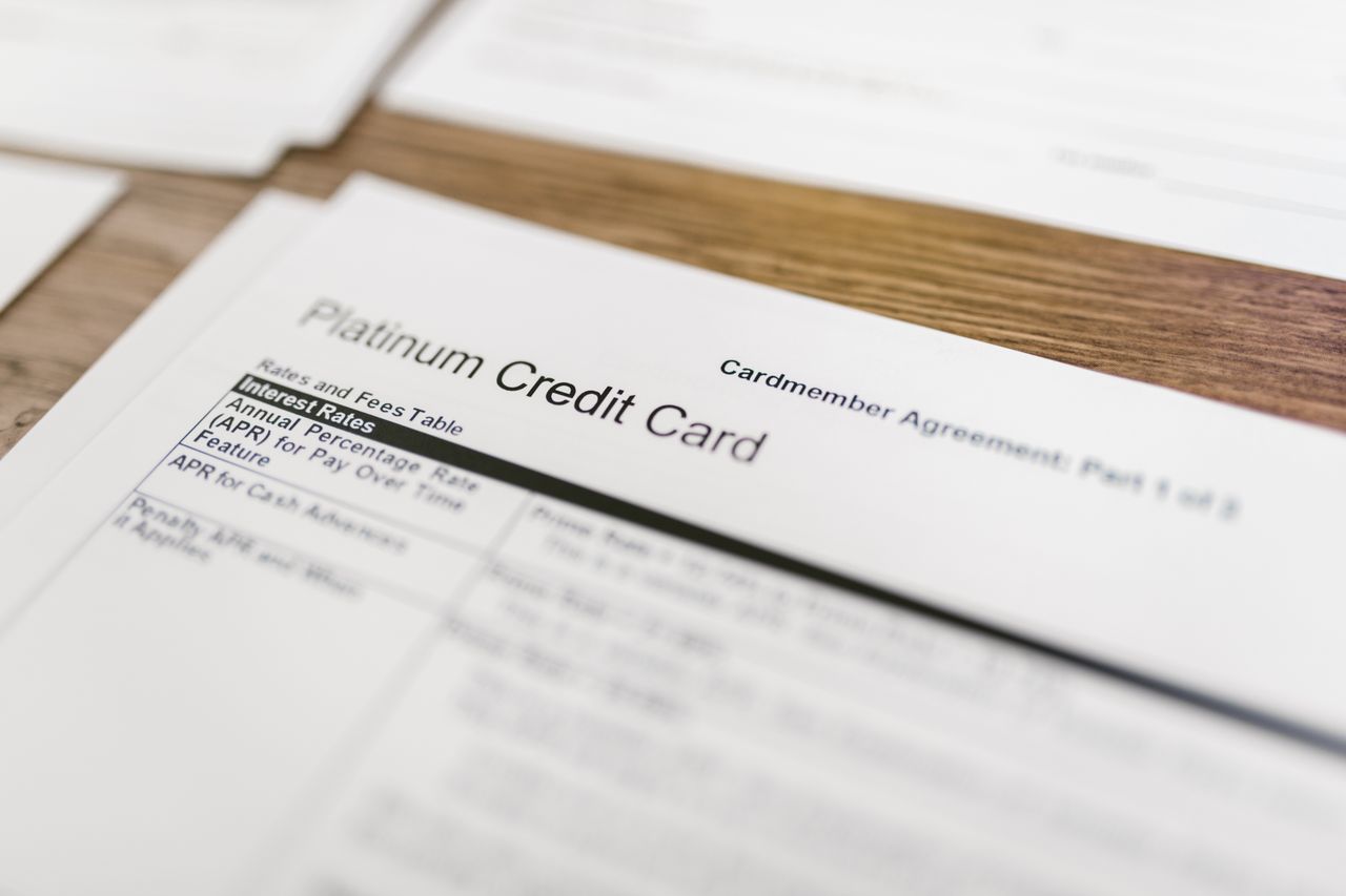 Dokumen formulir perjanjian pemegang kartu kredit Platinum Credit Card di atas meja kayu.