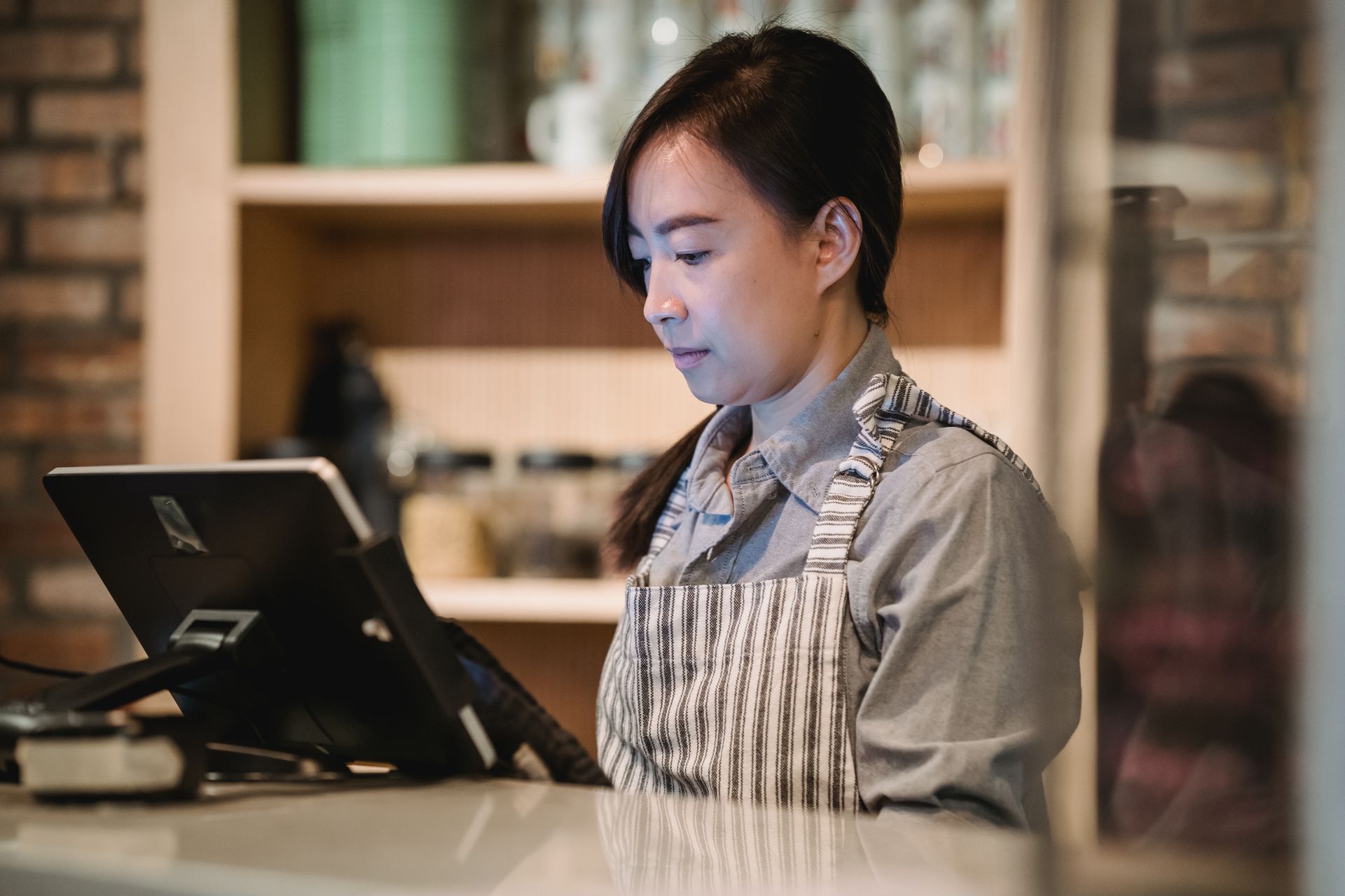 aplikasi-pos-digital-untuk-pengelolaan-transaksi Pengguna mengoperasikan aplikasi POS pada perangkat kasir untuk memproses transaksi bisnis
