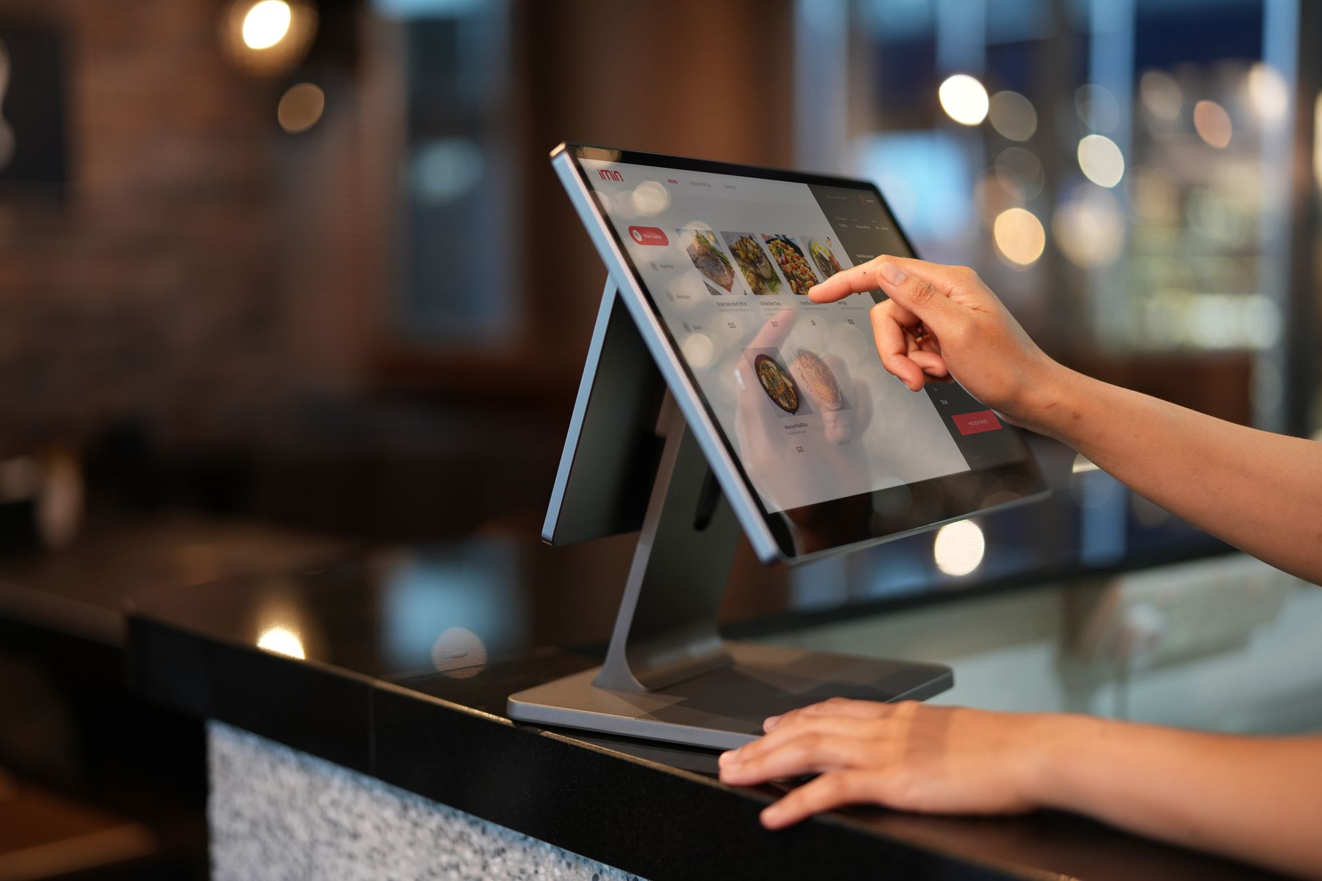 panduan-memilih-software-kasir-layar-sentuh-intuitif-kasair Tangan kasir memilih menu pada layar sentuh monitor POS cerdas yang menjalankan sistem Kasair POS