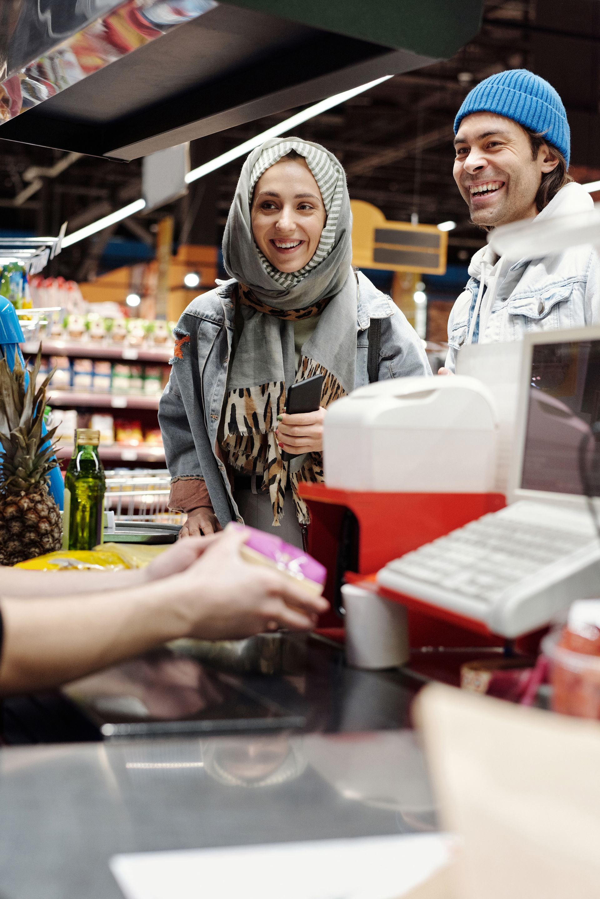 peran-sistem-pos-dalam-layanan-kasir-modern-kasair Pelanggan tersenyum saat kasir melakukan pemindaian produk dengan cepat menggunakan mesin Kasair POS