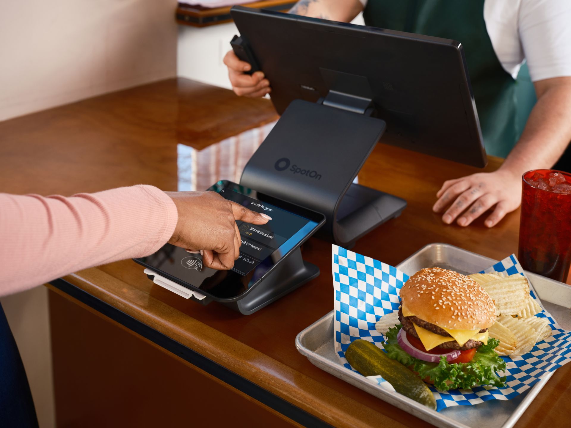 Pelanggan menyentuh layar interaktif Kasair POS untuk memilih program loyalitas dan promo menarik di meja kasir restoran