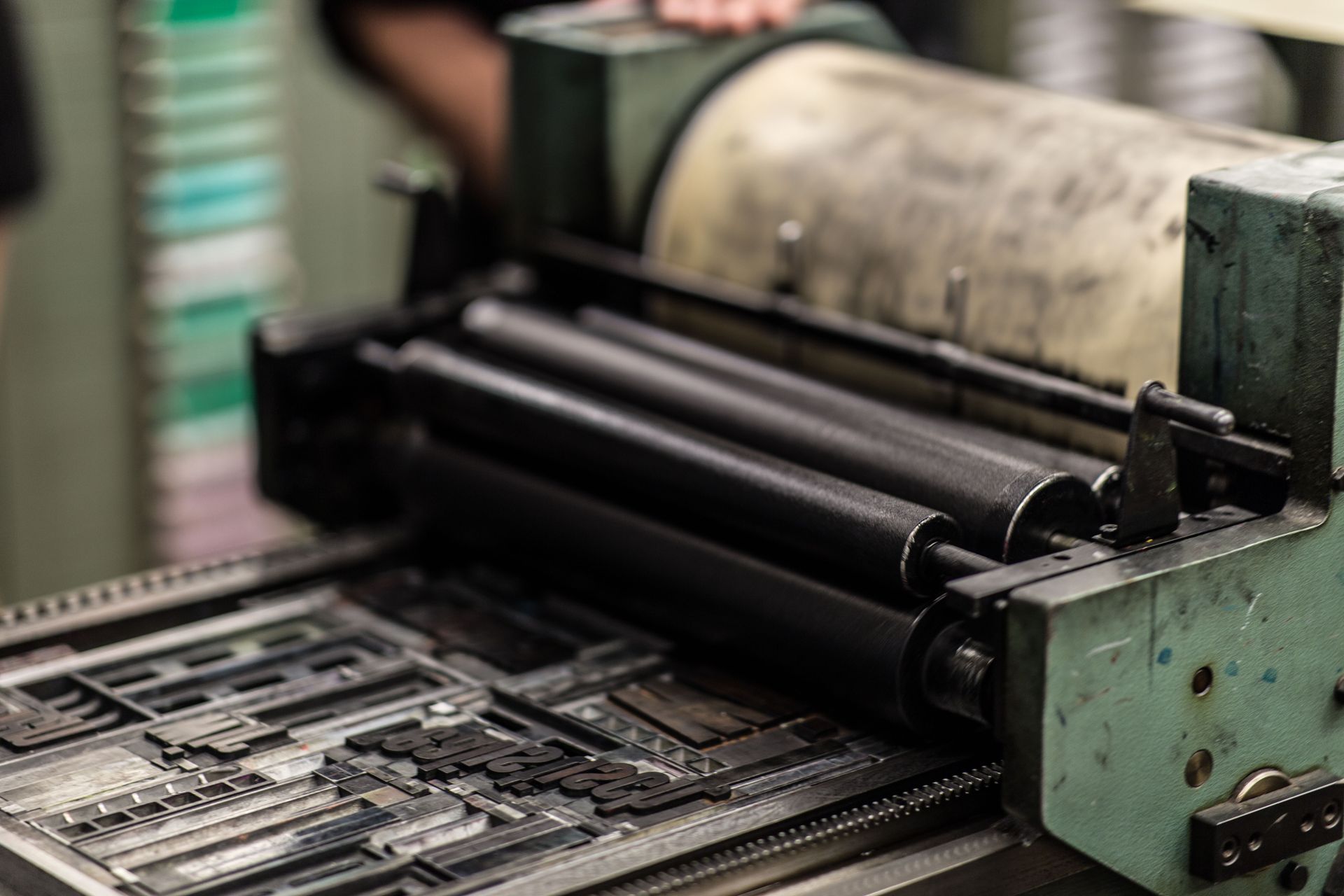Bagian dalam mesin cetak letterpress tradisional dengan roller rol tinta dan pelat cetak logam
