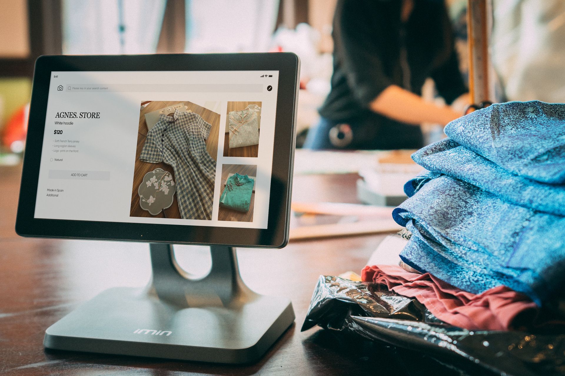 Layar mesin kasir Kasair POS menampilkan katalog produk pakaian di toko ritel fashion