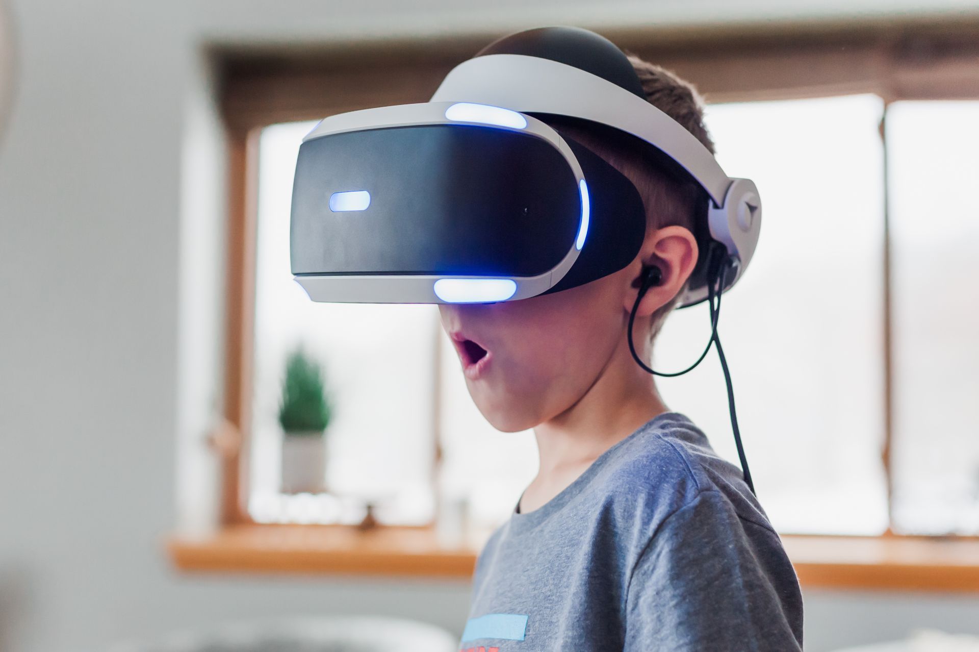 Penerapan Teknologi Augmented Reality untuk Meningkatkan Penjualan Anak menggunakan headset imersif dengan ekspresi kagum merasakan pengalaman teknologi Augmented Reality