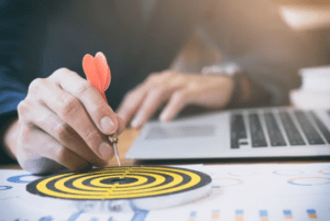 aplikasi-kasir-business-target-kasair Pebisnis menancapkan anak panah pada papan target untuk strategi pencapaian target penjualan aplikasi Kasair POS
